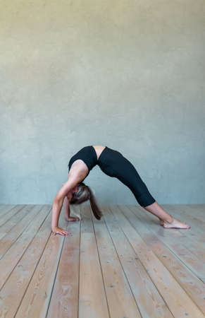 A young girl in sportswear does yoga, fitness at home, sports at home, stretching. high quality photoの写真素材