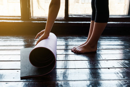 Close-up of young woman with exercise mat preparing for sports training. high quality photoの写真素材