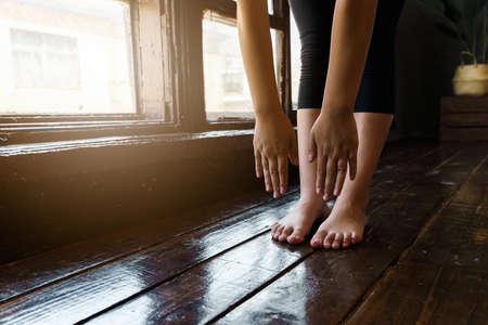 Close-up of a young woman getting ready for a sports workout. Reaches hands to the floor. high quality photoの写真素材