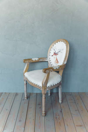 Upholstered French chair isolated on a gray background. White armchair with natural oak armrests. high quality photoの写真素材