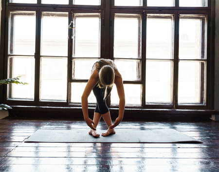 A young girl in sportswear does yoga, fitness at home, sports at home, stretching. high quality photoの写真素材