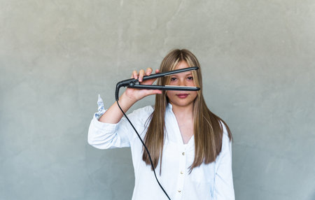 Young beautiful woman straightening her long hair. high quality photoの写真素材