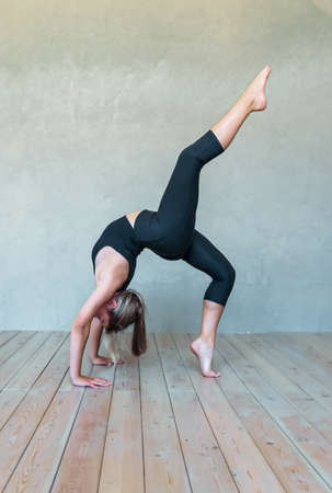 A young girl in sportswear does yoga, fitness at home, sports at home, stretching. high quality photoの写真素材