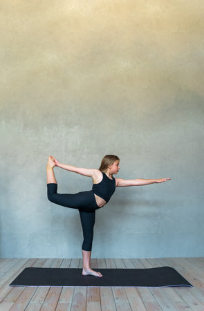 A young girl in sportswear does yoga, fitness at home, sports at home, stretching. high quality photoの写真素材