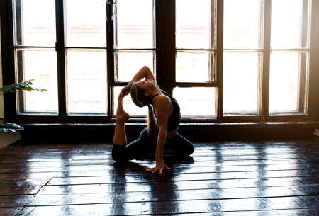 A young girl in sportswear does yoga, fitness at home, sports at home, stretching. high quality photoの写真素材