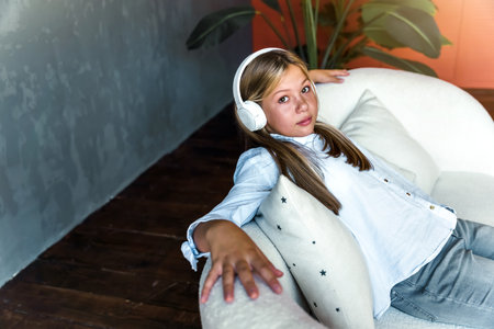 Portrait of a young girl with headphones on a gray background. high quality photoの写真素材