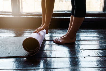 Close-up of young woman with exercise mat preparing for sports training. high quality photoの写真素材