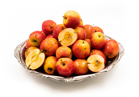 Ripe red small apples Ranetka on a metal plate, on a white background. high quality photoの写真素材