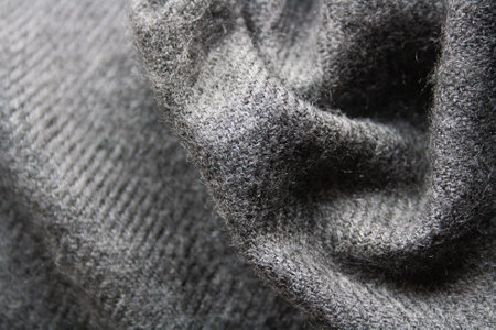 Knitted fabric in grey tones. Waved background.
