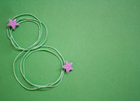 Number 8 of thin rope . Decorations of purple stars. Copy space