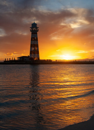 Backlit silhouette of a lighthouse on a Bahamian beach in a summer sunset.Copy space.の写真素材