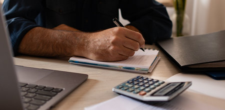 Businessman taking notes at his workplace. Modern office. Young man working.の写真素材
