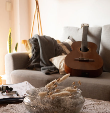 The sun comes through the window in a minimalist living room. Modern decoration concept. Instruments and elements for a guitar lesson. Copy spaceの写真素材