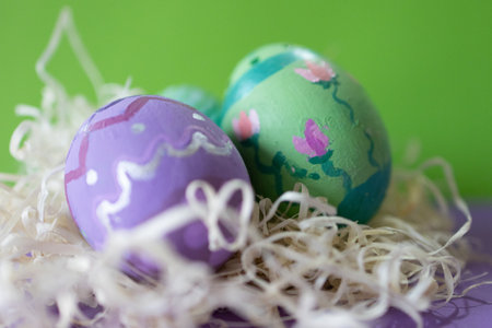 Hand made Easter eggs among wood shavings. Homemade painted decoration. Horizontal real picture....