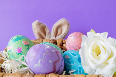 Colored Easter eggs and funny bunny in purple background .Copy sapce.Wallpaper for Easter...
