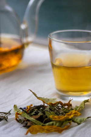 Close up of wild herbs and herbal tea in a peaceful outdoor setting by a lake, symbolizing...