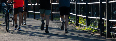 Horizontal cut of people running in the park. Fitness and wellness lifestyle. Horizontal real picture with space for text. Especially for sports campaigns, healthy outdoor living.の写真素材