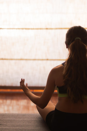Tall picture of girl practicing yoga and relaxing at home , ideal for wellness projects, fitness visuals, and mindfulness promotions.の写真素材
