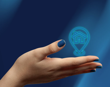 Woman hand holding digital house icon, concept of buying a new home, renting, and property management. Perfect for mortgage ads, realtor visuals, and housing promotions.の写真素材