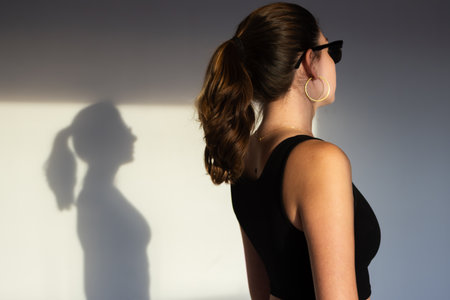 Fashion portrait of teenager with soft shadows, great for lookbooks, design portfolios, and contemporary brand campaigns. Horizontal picture.の写真素材