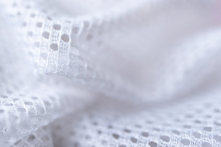 Horizontal shot of perforated fabric texture with soft waves, ideal for product mockups.Selective...