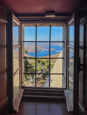 Old window, with open wooden shutters and metal grate, offering a stunning high angle panorama of a...