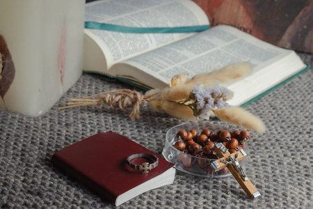 Christian religious objects symbolizing faith and prayer. Including an open Bible. A rosary with...