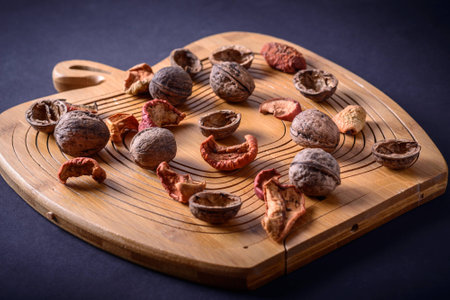 Walnuts and dried fruits on a wooden board in apple form