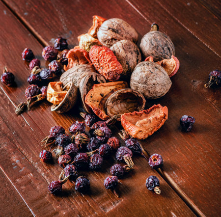 a pile of dried fruits, walnuts and dried berries rose hips on the wooden tableの写真素材