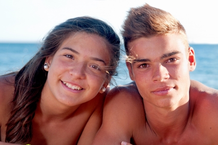 teenage girl and boy posing in the beachの写真素材