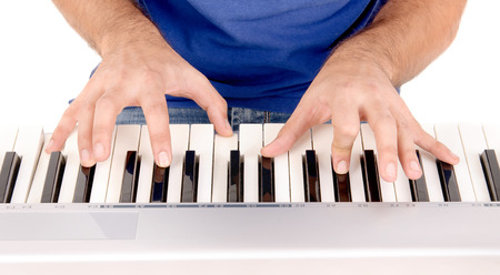 handsome young man playing the piano isolated in white background