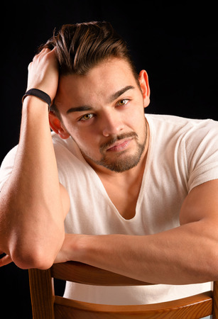 handsome young man isolated in dark backgroundの写真素材