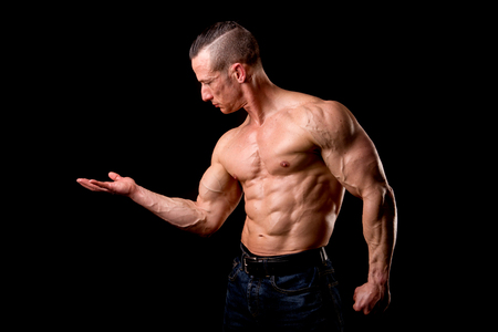 fit muscular man posing isolated on a dark backgroundの写真素材