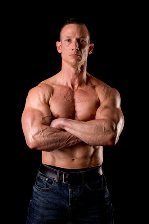 fit muscular man posing isolated on a dark backgroundの写真素材