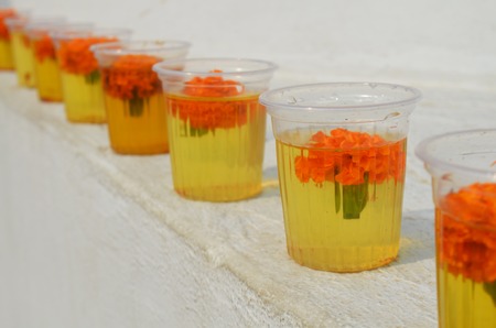 Glasses with water and carnation flowers at The Great stupa Bodnath in Kathmandu, Nepal. Buddhist offeringsの写真素材