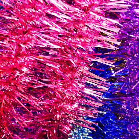Bright christmas background from colored tinsel. Colored metal foil. Close-up. View from above.