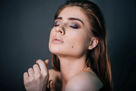 beauty portrait. Studio portrait of a beautiful girl on a gray background. Good make-up. Face closeupの写真素材