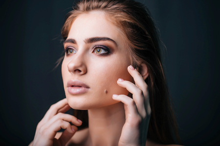 beauty portrait. Studio portrait of a beautiful girl on a gray background. Good make-up. Face closeupの写真素材