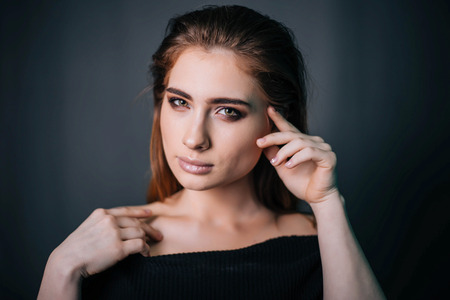 beauty portrait. Studio portrait of a beautiful girl on a gray background. Good make-up. Face closeupの写真素材