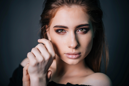beauty portrait. Studio portrait of a beautiful girl on a gray background. Good make-up. Face closeupの写真素材