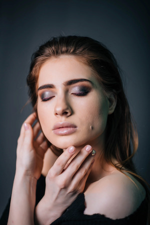 beauty portrait. Studio portrait of a beautiful girl on a gray background. Good make-up. Face closeupの写真素材