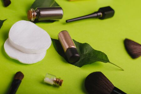 Scattered cosmetics on a green background.の写真素材