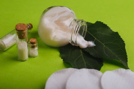 Eco cosmetics. A jar of white cream and the leaves of the tree on a green background. Skin care.の写真素材