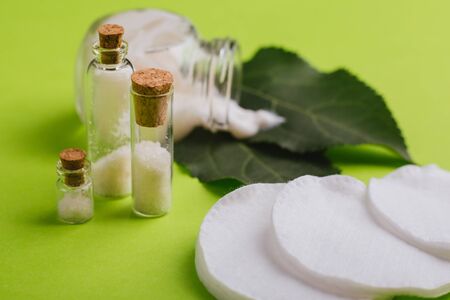 Eco cosmetics. A jar of white cream and the leaves of the tree on a green background. Skin care.の写真素材