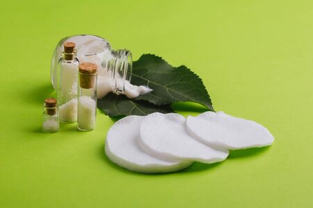 Eco cosmetics. A jar of white cream and the leaves of the tree on a green background. Skin care.の写真素材