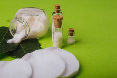 Eco cosmetics. A jar of white cream and the leaves of the tree on a green background. Skin care.の写真素材