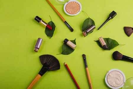Scattered cosmetics on a green background.の写真素材