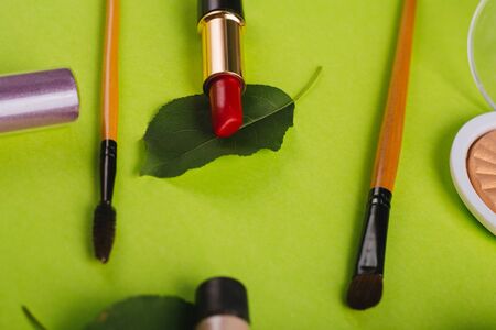 Scattered cosmetics on a green background.の写真素材