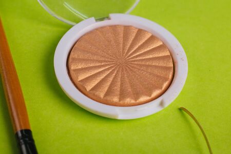 Cosmetics. Round highlighter on a green background.の写真素材