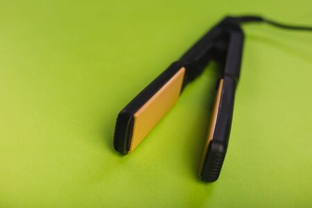 Black Hair Straighteners on a green background.の写真素材